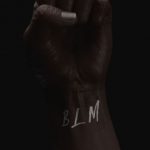 Photo of a raised fist with BLM on the wrist.