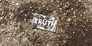 A card reading "truth" in the dirt.