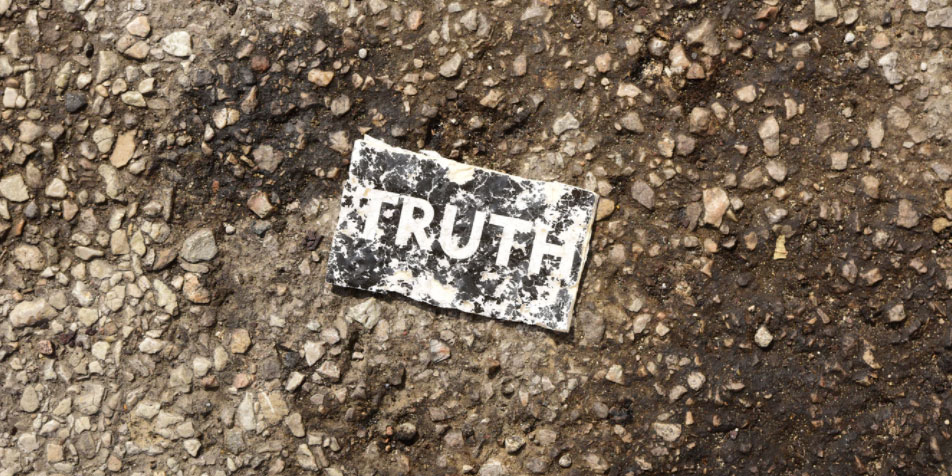 A card reading "truth" in the dirt.