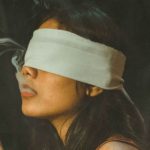 Blindfolded woman smoking