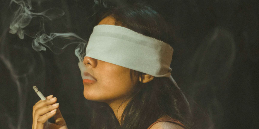 Blindfolded woman smoking