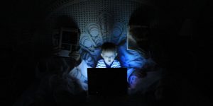 Child on computer in parents' bed