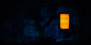 A lighted for hire sign at night