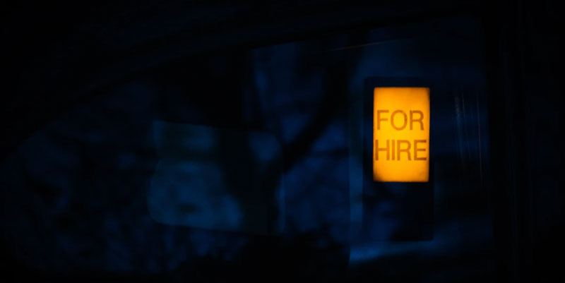 A lighted for hire sign at night