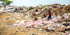 A boy rummages through trash at the dump