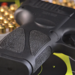 A handgun, bullets, and target