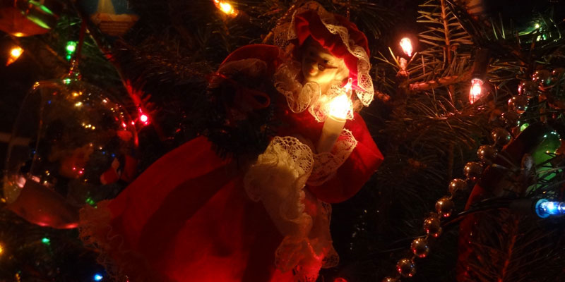 A Mrs. Claus ornament on a Christmas tree