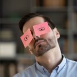 Office worker sleeping with Post-It Note eyes