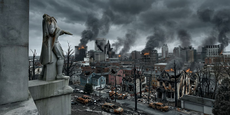 A headless Roger Williams statue stands of the smoking ruins of Providence